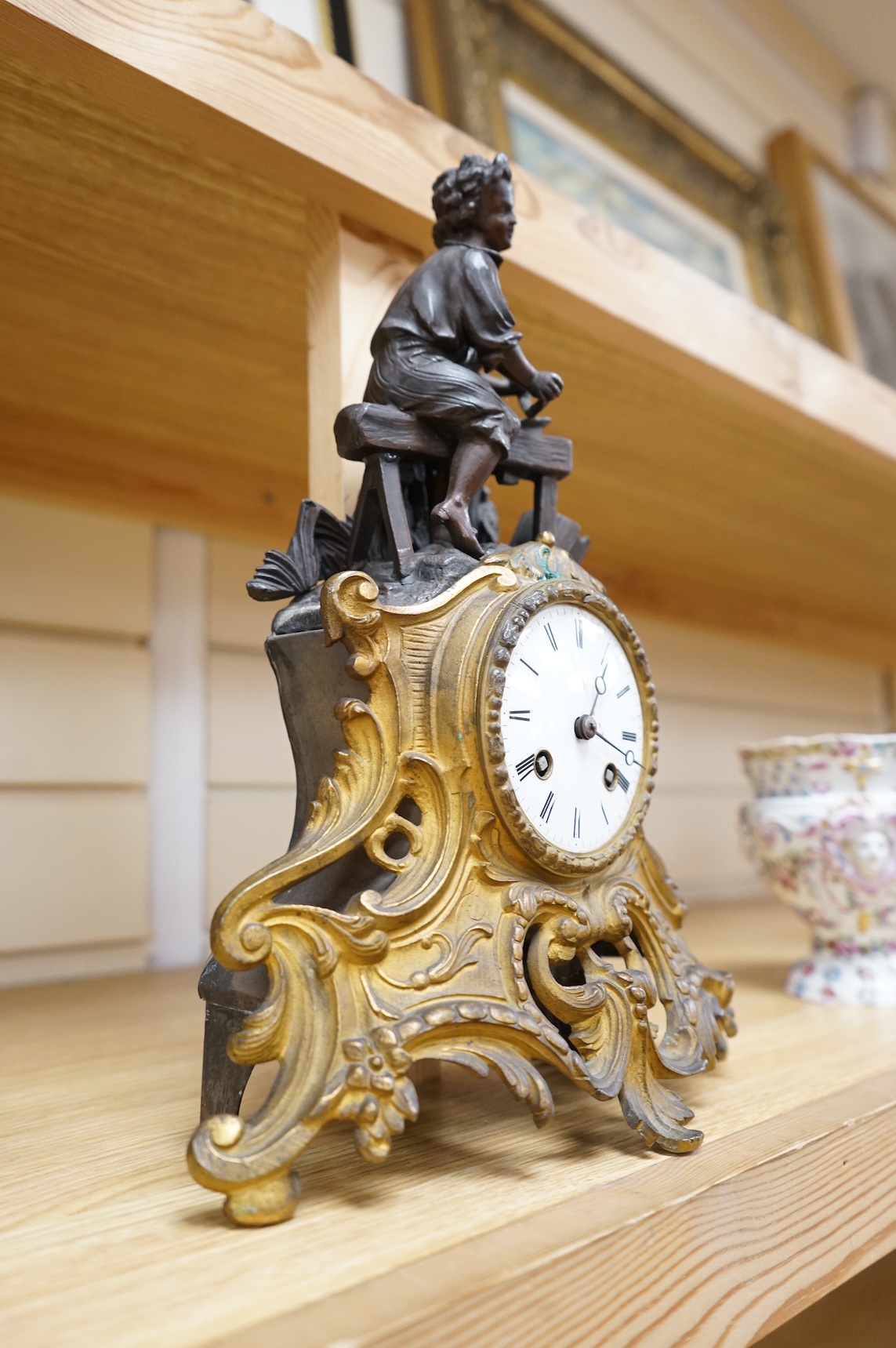 A French gilt and patinated spelter mantel clock, with artisan worker mount. 32cm high